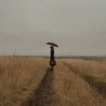 Самотна жена с чадър в поле